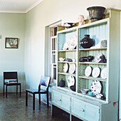 Painted green dresser with display of ceramics plates and pots