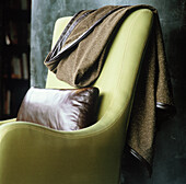 Upholstered suede chair with throw
