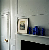 Blue glass vase collection on mantlepiece