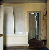 Duschabtrennung aus Carrara-Marmor über der Badewanne in einem holzgetäfelten Badezimmer