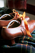 Close up of vintage ladies leather shoes and tartan throw 