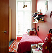 Red and white decorated single bedroom with casement windows