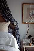 Detail of decorative bedroom upholstery and side table with ornaments