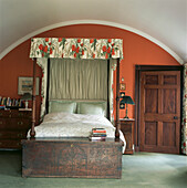 Bedroom with four poster bed underneath barrel vaulted ceiling