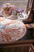 Nahaufnahme eines Perlmutt-Mosaik-Tabletts mit einem dekorativen Tortenständer aus Glas, gefüllt mit Seidenblumen, in einer dekorativen Wohnwagenküche