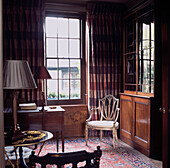 Dark tones in elegant drawing room with antique wooden furniture