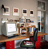 Heimbüro im Budget-Stil mit Holztischplatte auf roten Ikea-Aktenschränken