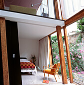 Zwischengeschoss über dem Schlafzimmer mit Blick durch ein schräges Panoramafenster in einem offen gestalteten Architektenhaus