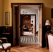 View from lounge through large double oak doors into hallway and dining room in a French chateau