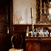 Drinks in carafes and crystal glasses displayed on a cabinet in a rustic country style dining room 