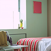 Modernes Schlafzimmer mit moderner Keramik und zeitgenössischem Stuhl mit einem antiken italienischen Streifenstoff auf dem Bett