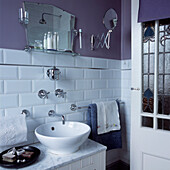 Bathroom with white vintage style tiles purple painted walls and metal bathroom accessories