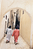 Zwei einheimische Frauen gehen eine schmale Straße in der Medina von Fez in Marokko hinauf