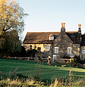 Exterior of country house and garden with arched windows and stone walls