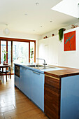 Offene, moderne Küche mit großen Glasschiebetüren zum Garten