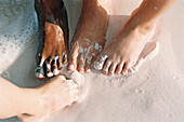 Close up of children's feet in the sand on the beach