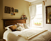 Double bed with mohair blanket and Icons hanging above a vintage wooden bed head