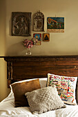 Double bed with Icons hanging above a vintage wooden bed head