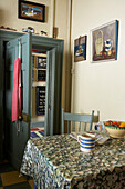 Kitchen table with pebble patterned oilskin tablecloth and view through to hall