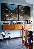 Landing with large artwork and wall hung drawers with group of nostalgic objects