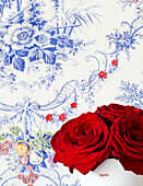 Red roses and blue floral wallpaper
