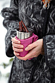 Woman holding a metal cup of mulled wine