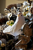 Detail of white dove in festive christmas garland draped over a mantlepiece