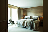 Wood panelled twin room in shades of grey in luxury Zermatt home, Switzerland