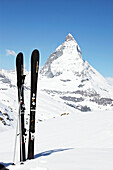Skier und Skistöcke mit Blick auf das Matterhorn in Zermatt, Wallis, Schweiz