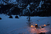 Beleuchtete Ölbrenner und Kohlenbecken im Waldschnee, Zermatt, Wallis, Schweiz