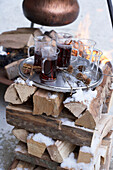 Hot drinks on silver tray stacked on firewood, Zermatt, Valais, Switzerland