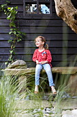 Girl sitting in garden of London townhouse, England, UK
