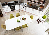 Elevated view of dining table with lime green chairs in contemporary London kitchen, England, UK