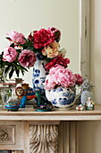 Cut flowers in chinaware on mantlepiece in London townhouse, England, UK