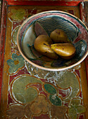 Three pears in hand painted bowl on tabletop in London home, England, UK