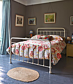 Floral duvet on metal framed bed with artwork in Rye family home, East Sussex, England, UK