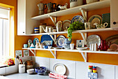 Assorted home and kitchenware on open shelves in Hackney kitchen, East London, UK