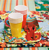 Colourful picnic ware on a patterned fabrics