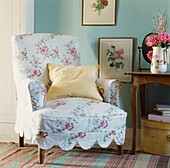 Floral patterned armchair with yellow cushion and botanical prints