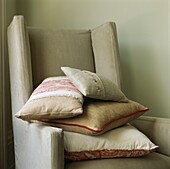 Cream coloured cushions on upholstered armchair