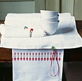 Weiße Schalen auf Platzdeckchen mit handgefertigten Servietten