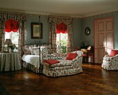 Co-ordinated floral prints in bedroom with red accent