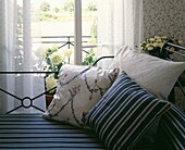 Metal daybed at French doors with co-ordinated stripes and cushions