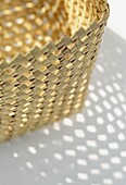 Sunlight refracts through woven basket