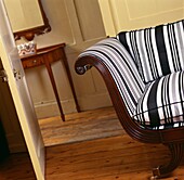 Gestreifter Stuhl mit Kissen an der offenen Tür zum Flur