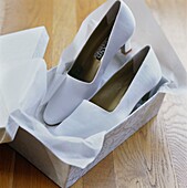 Pair of shoes with wrapping paper in shoebox