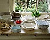 Kitchenware bowls on marble topped kitchen worktop at windowsill