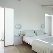 Contemporary white bedroom with frosted glass sliding doors and modern double bed