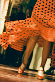 Flamenco-Tänzerin in einem rot gepunkteten Kleid bei einem Auftritt in einem Tablaos in Sevilla