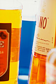 Detail of cocktail bar shelf with coloured spirit and liqueur bottles